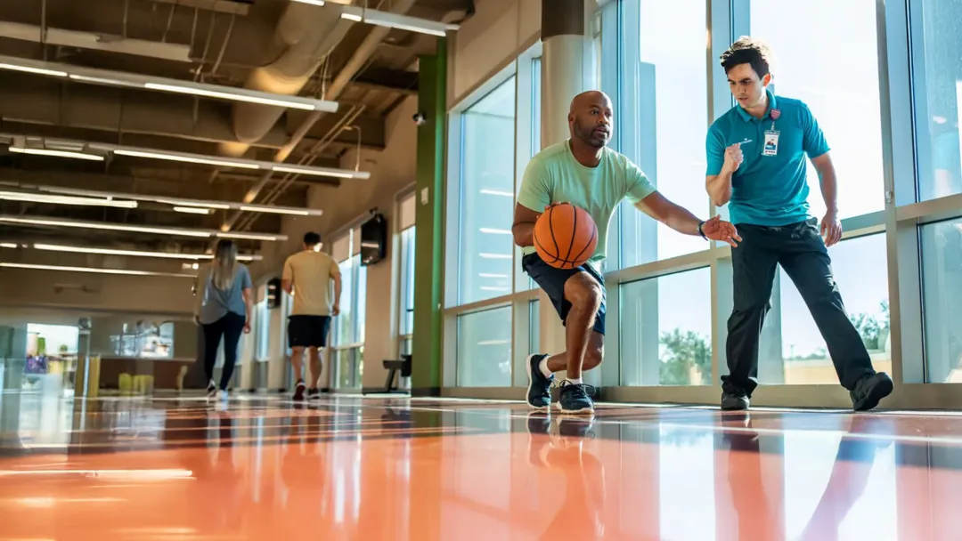 Man doing basketball drills with trainer