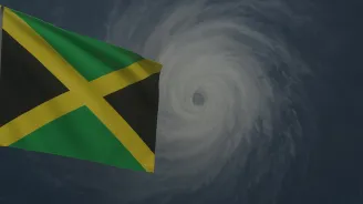 Picture of Jamaica flag with hurricane in background 