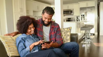 Black Couple Looking at Report on Tablet