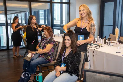 Women attending the Women’s Health and Cancer Prevention Event, having their hair done professionally.