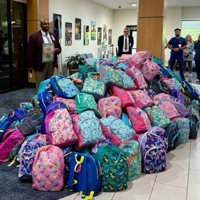 Derrick Hough, AdventHealth DeLand pastoral care chaplain, blesses the backpacks and prepares to pray for the students and teachers.