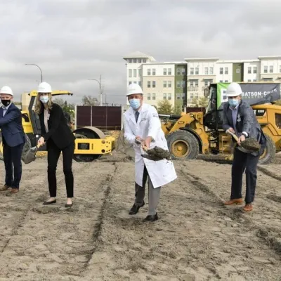 5 executives shovel dirt at Rothman Groundbreaking event