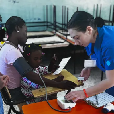 Mission trip worker provides care to woman and girl in Dominican Republic.
