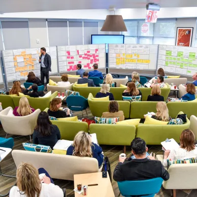 A group meets in a large office space for a strategic meeting.