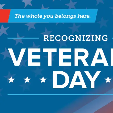 A banner reads: Recognizing Veterans Day. It features a waving U.S. flag and a marine standing at attention.