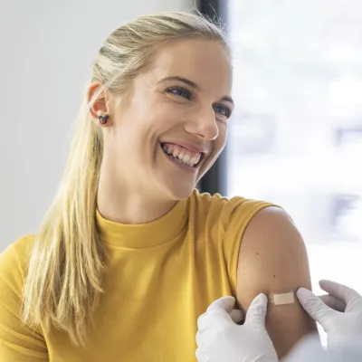A woman getting a bandaid after a flu shot.
