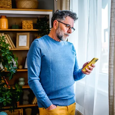 A middle-aged man reading info on his phone.