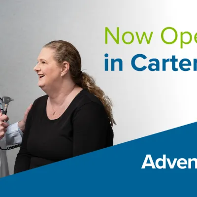 A male doctor laughs with a female patient. Text reads, "Now Open in Cartersville" and "AdventHealth Medical Group."