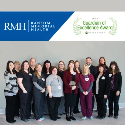 A group of co-workers standing next to each other.