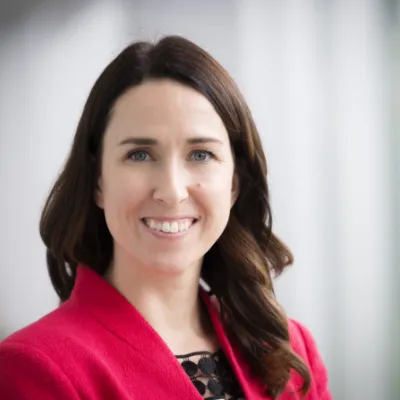 Gina Creek, woman with brown hair and blue eyes, smiles at the camera