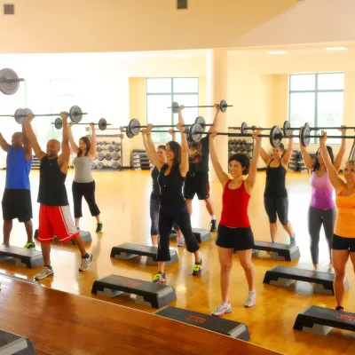 A group of people lighting weights at a fitness class. 
