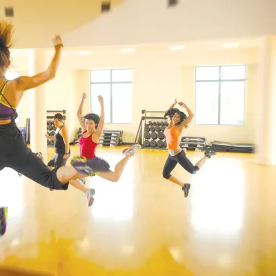 A group of women exercising at the gym while doing a group class. 