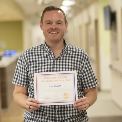 Jason Smith holding an award. 