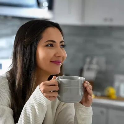 Woman Drinking Tea in Kitchen.