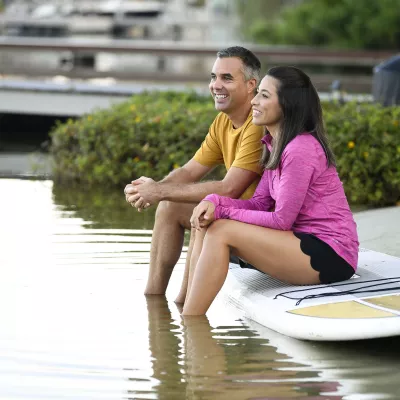 Father and Daughter sitting on a surfboard