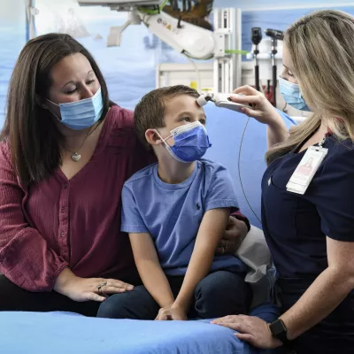 Pediatrician with boy and his mother in office
