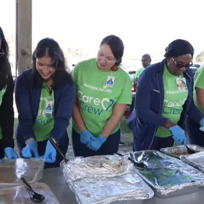 AdventHealth Zephyrhills volunteers serve food at Southern Charm RV Resort for Thanksgiving.