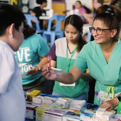 A nurse assisting a young boy from the Philippines