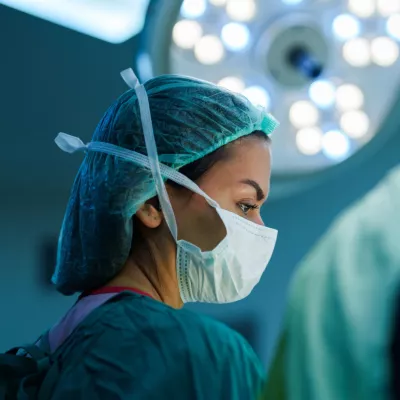 A surgeon wearing a mask performing surgery