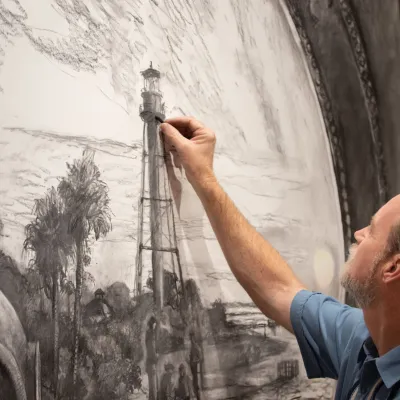 Photo of Chris Still drawing a mural