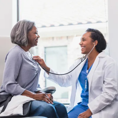 Doctor listens to patient with stethoscope.