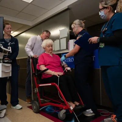 Members of the AdventHealth Redmond stroke team attend a patient in a wheelchair who appears to be experiencing symptoms of a stroke.