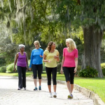 A group of mature ladies walking outdoors while chit-chatting