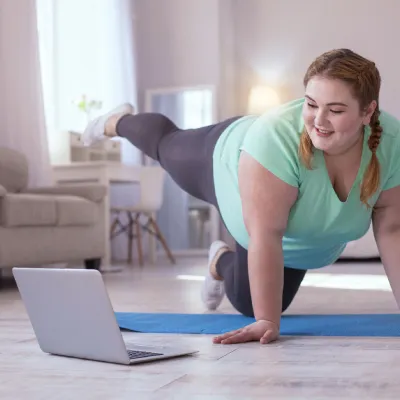 A lady doing exercises in front of her laptop
