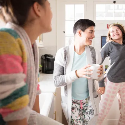 Family dancing in kitchen during breakfast.