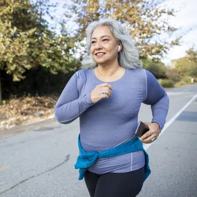 Older woman running along a road