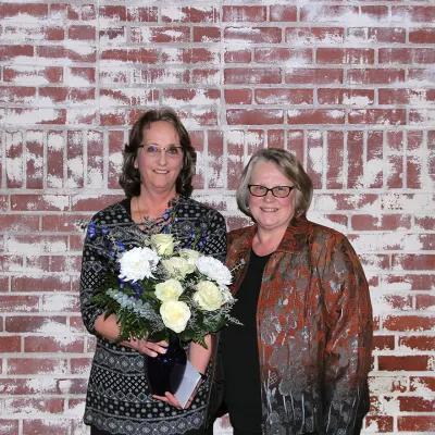 Two women receiving a flower arrangement.