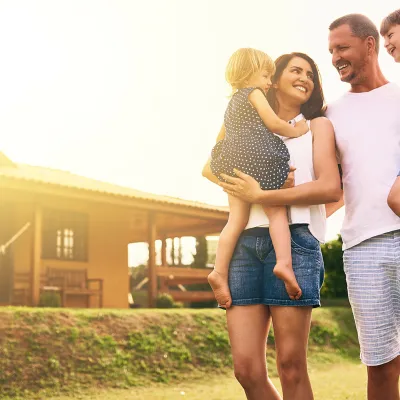 Mother and father walking with children in their front yard