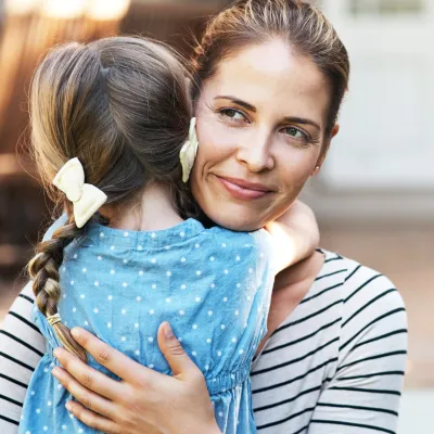 A mother hugs and comforts her daughter.