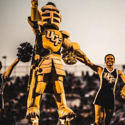 The UCF mascot and cheerleaders during a football game.