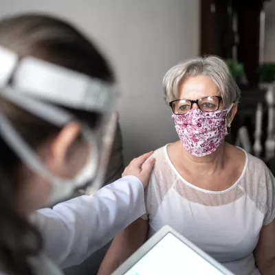 A physician reassuring her patient while they are talking