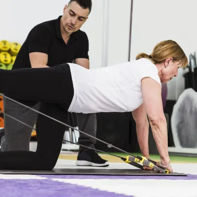 A woman doing a core exercise with a trainer.