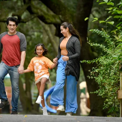 Smiling family walking together in a park, representing wellness, balance, and whole-person care at AdventHealth.