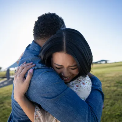 Man and woman hug in field