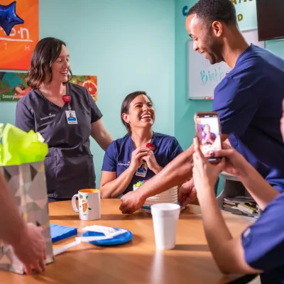 AdventHealth team members gather at a table to celebrate.