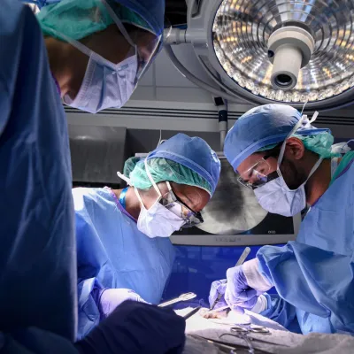 Surgeons perform a surgery in an operating room.