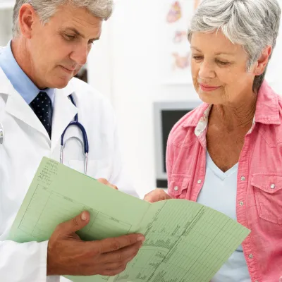 Senior patient and physician reviewing health information document