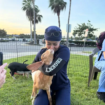 An AdventHealth Team member hugging a goat