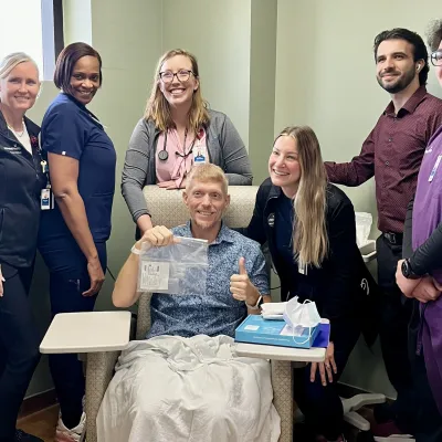 Jeff Bishop surrounded by medical team at AdventHealth. 