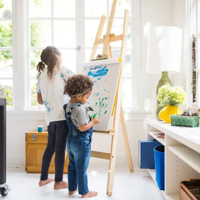Two little girls painting a canvas in the craft room.