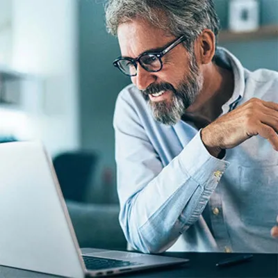 Middle-aged man with glasses using laptop