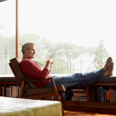 A man sits by a window at home