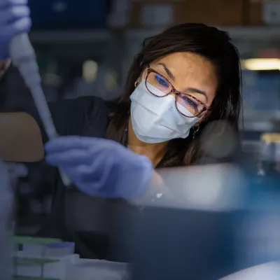 Masked Woman in Lab holding a syringe