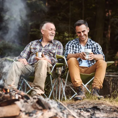 A father and son sitting in front of a campfire