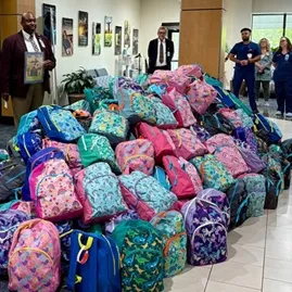 Chaplain Derrick Hough blessing the backpacks