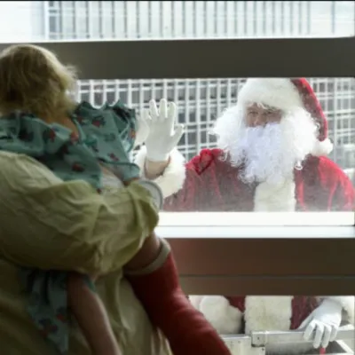 Santa Claus appears outside the sixth-floor window of AdventHealth for Children to greet a young patient.